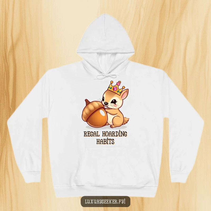 Funny hoodie depicting a tiny squirrel wearing a jeweled crown, admiring its reflection in a shiny acorn, perfect for cozy wear.